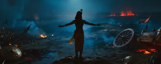 Warrior with arms outstretched on a ridge above a burning night battlefield strewn with banners and a broken chariot wheel